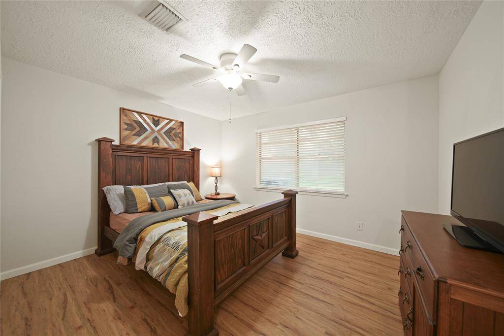 This secondary bedroom has a warm and inviting atmosphere thanks to the abundance of natural light. Ceiling fans in each room ensure comfort, making this space perfect for relaxation and restful nights.