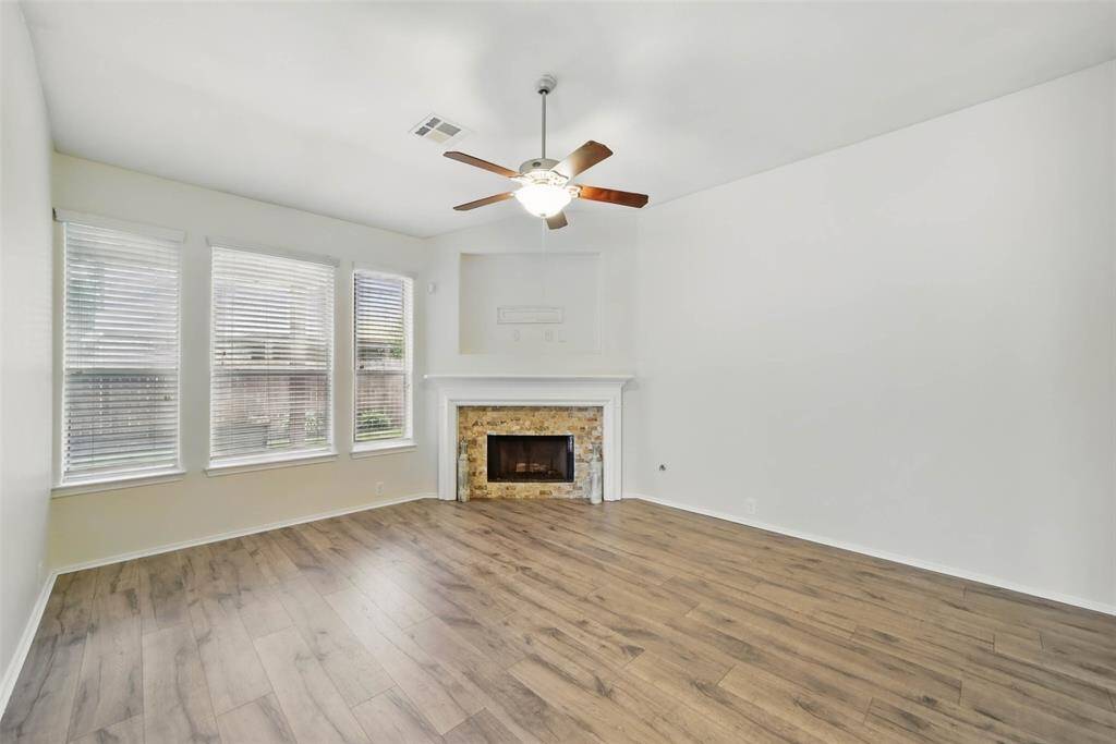 Spacious family room features corner gas log fireplace, TV nook and wall of windows overlooking the backyard. Recent laminate flooring and paint.
