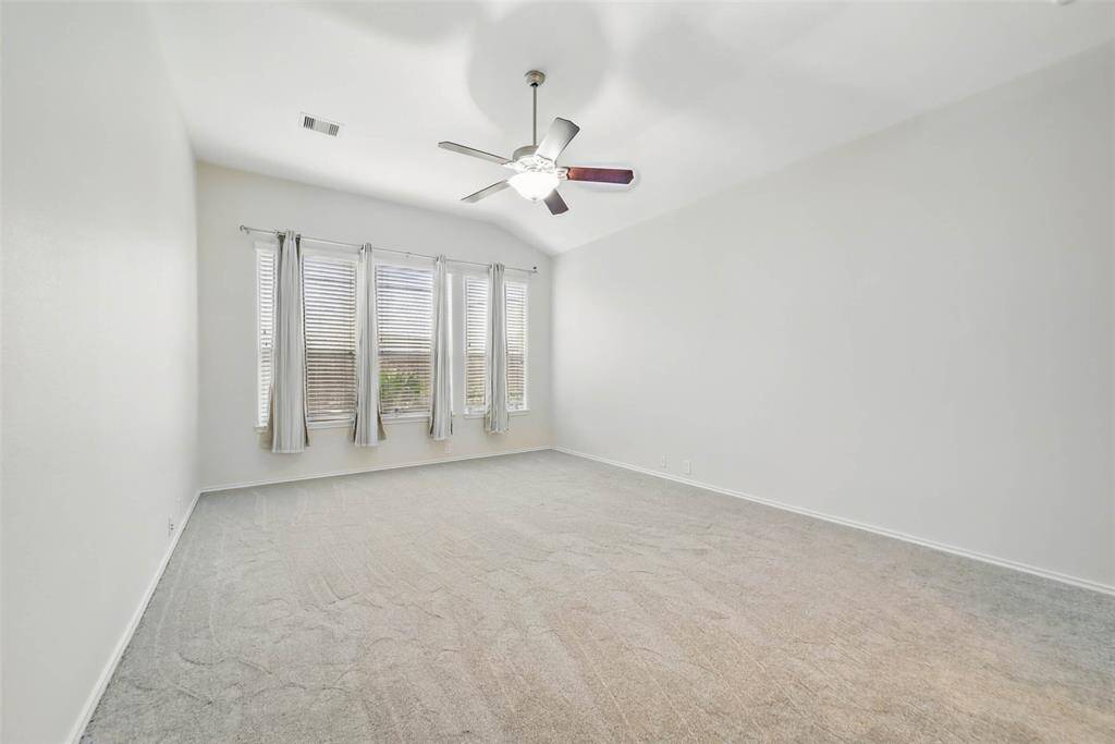The primary suite offers a serene retreat with updated carpet and high ceilings.