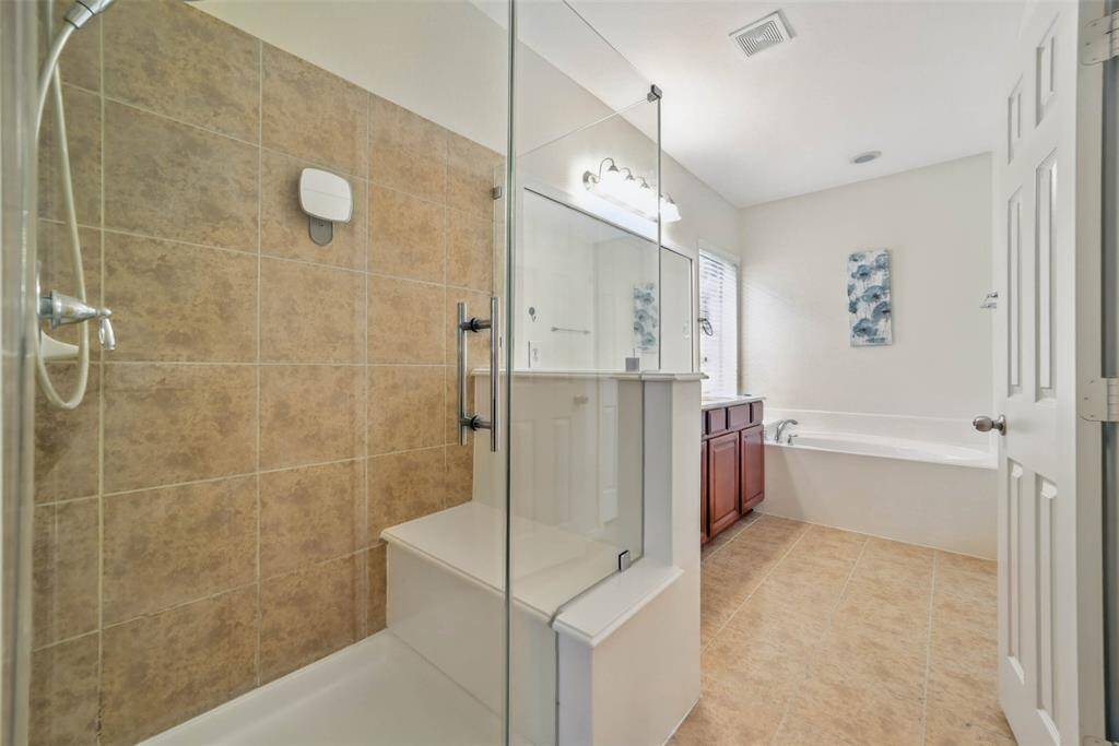 Primary bath features a separate walk-in shower with seat.
