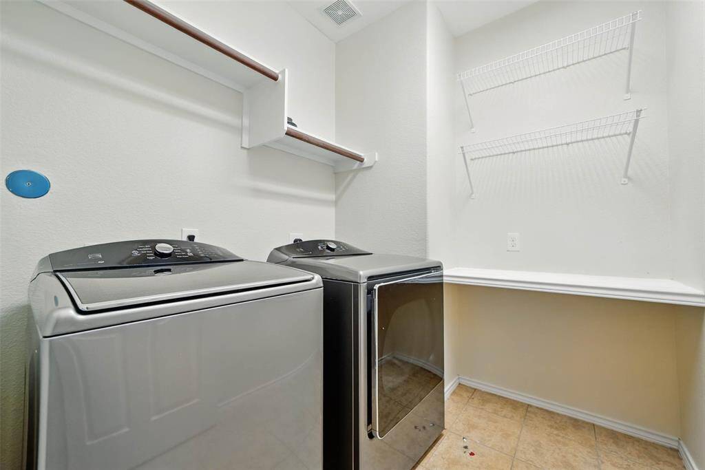 Conveniently located laundry room with built-in shelves and counter.