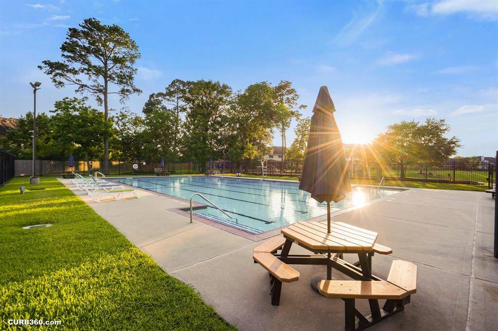 Enjoy serene sunsets by the sparkling community pool, surrounded by lush greenery. Perfect for relaxation and leisure.