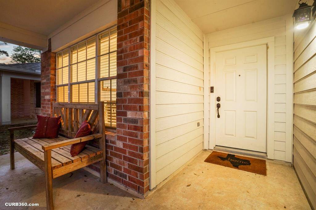 Welcoming front porch with charming brick accents, cozy seating, and a warm ambiance. Ideal for relaxing evenings.