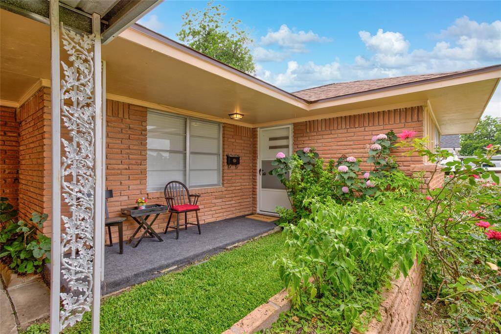 Charming entryway with lush greenery and inviting seating, perfect for relaxation.