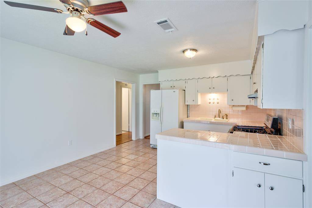 View of the bright kitchen from the versatile living/office space.