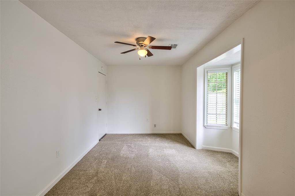 The carpeted floor makes it an ideal spot for comfort, whether used as a home office, a reading nook, or a play area. Its proximity to the kitchen allows for easy access, making it a functional space for multitasking or entertaining.