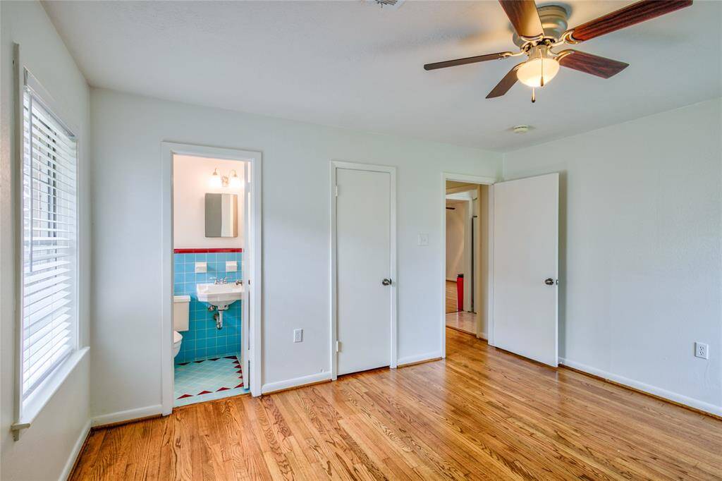 Adjoining the primary bedroom is a half bath that boasts stylish original blue tile, which adds a vibrant splash of color and character to the space. The primary bedroom and the first bedroom also have walk-in closets for all your storage  needs.
