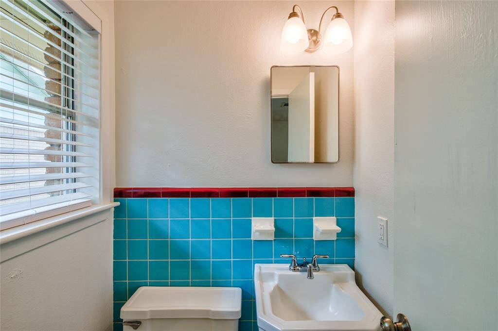 The fun designs within the tile create a playful yet sophisticated vibe, making the half bath a delightful feature of the bedroom. Together, the combination of the inviting flooring and the unique bathroom tiles contributes to a cohesive and stylish aesthetic, making this primary bedroom a true sanctuary.