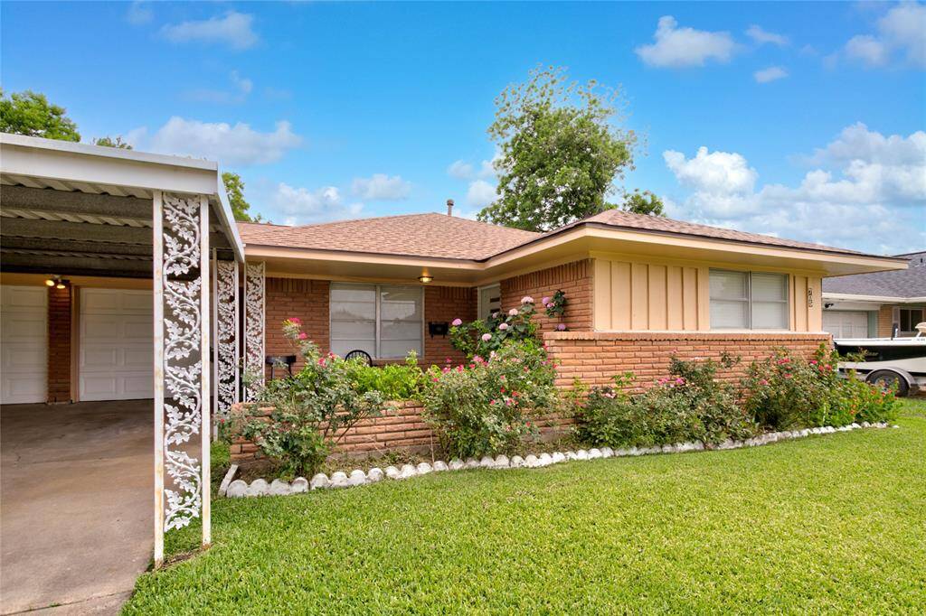 The front of the home features a quaint small porch that adds a cozy touch, inviting visitors to come inside. The entryway is beautifully designed, showcasing elegant details that enhance its appeal. Flanking the entrance are vibrant flowers in the entry area, bringing a a splash of color and a sense of warmth to the overall ambiance.