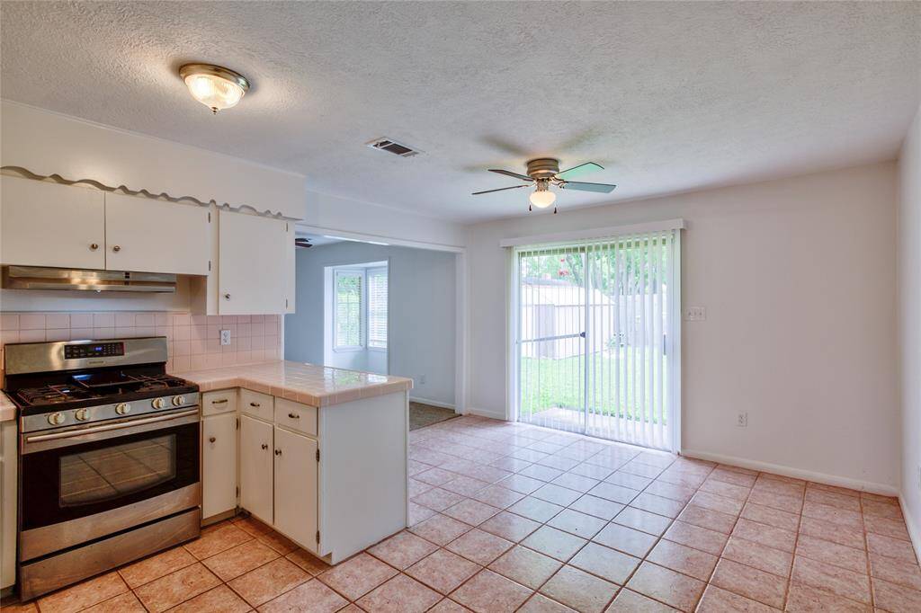 Discover the kitchen's charm with its restored light pink countertops, offering a warm and elegant contrast to the cabinetry.