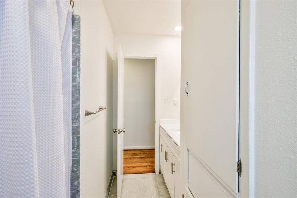 This restroom combines modern and classic elements with a chic new vanity offering ample storage, and a charming original tub serving as a stunning focal point.