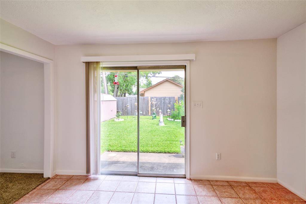 A view of the sliding door in the kitchen which leads to the backyard. This beautiful glass door brings in lots of sunshine.