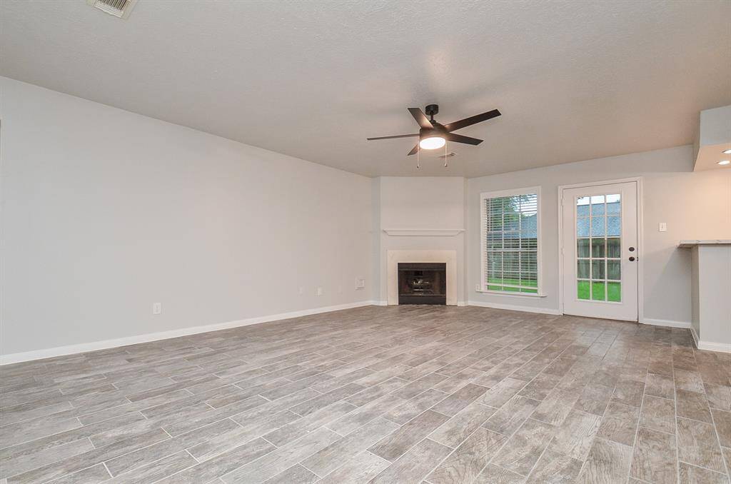 The wood grain tile is cohesively installed throughout the entire home which enhances the feel of this open floor plan.