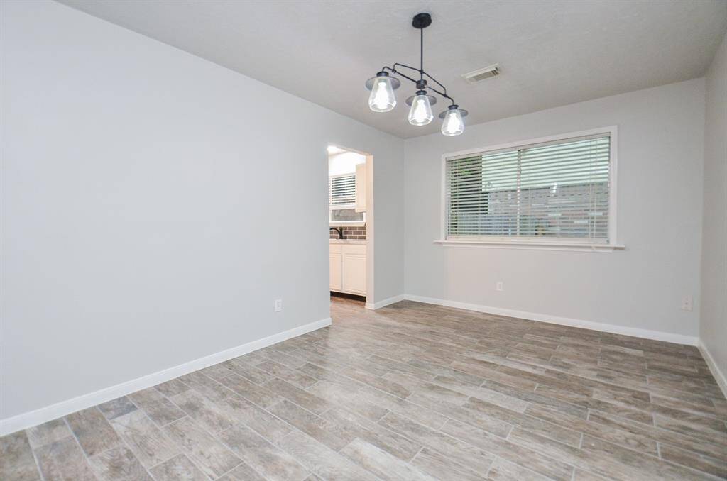Designer modern light fixtures are echoed throughout the home along with this dining area example.