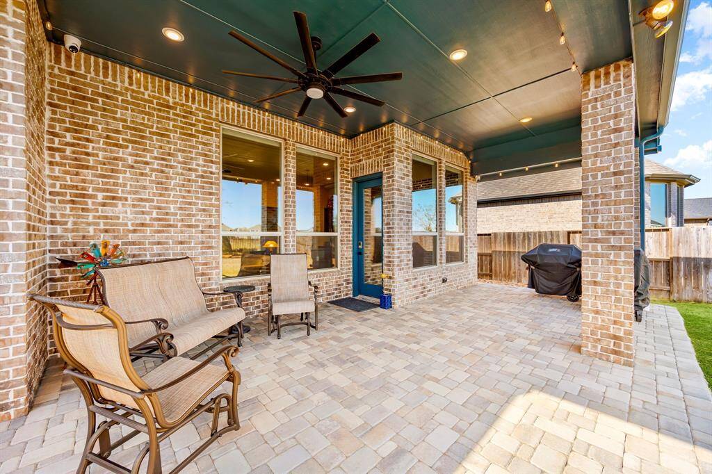 Experience outdoor living at its finest with this stunning covered patio. Featuring elegant brick columns, recessed lighting, and a stylish ceiling fan, this space is perfect for year-round enjoyment. The beautiful paver flooring adds charm, while the spacious layout offers endless possibilities for relaxation and entertainment.