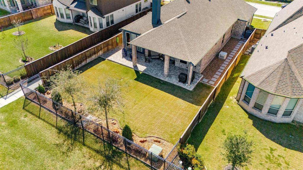 Step into luxury with this beautifully designed backyard oasis, featuring a spacious covered patio, elegant brick accents, and lush green landscaping. Perfect for entertaining, this outdoor space offers cozy seating areas, string lighting, and a built-in grilling station. Enjoy breathtaking sunsets in a serene setting, all within a vibrant neighborhood. Don't miss the chance to make this dream home yours!