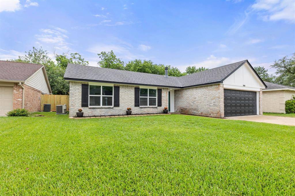 This is a charming single-story brick home with a neat, well-maintained lawn. It features a two-car garage with a dark door, large front windows, and a simple yet appealing facade. Situated in a quiet neighborhood, it offers a welcoming atmosphere.