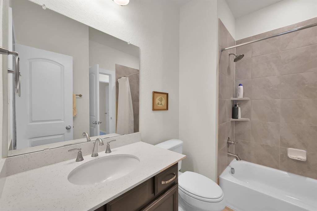Bathroom with tub/shower combo and vanity with plenty of storage.