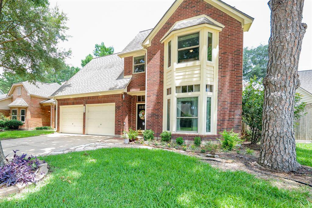 Charming curb appeal with beautiful trees and vibrant flowerbeds.