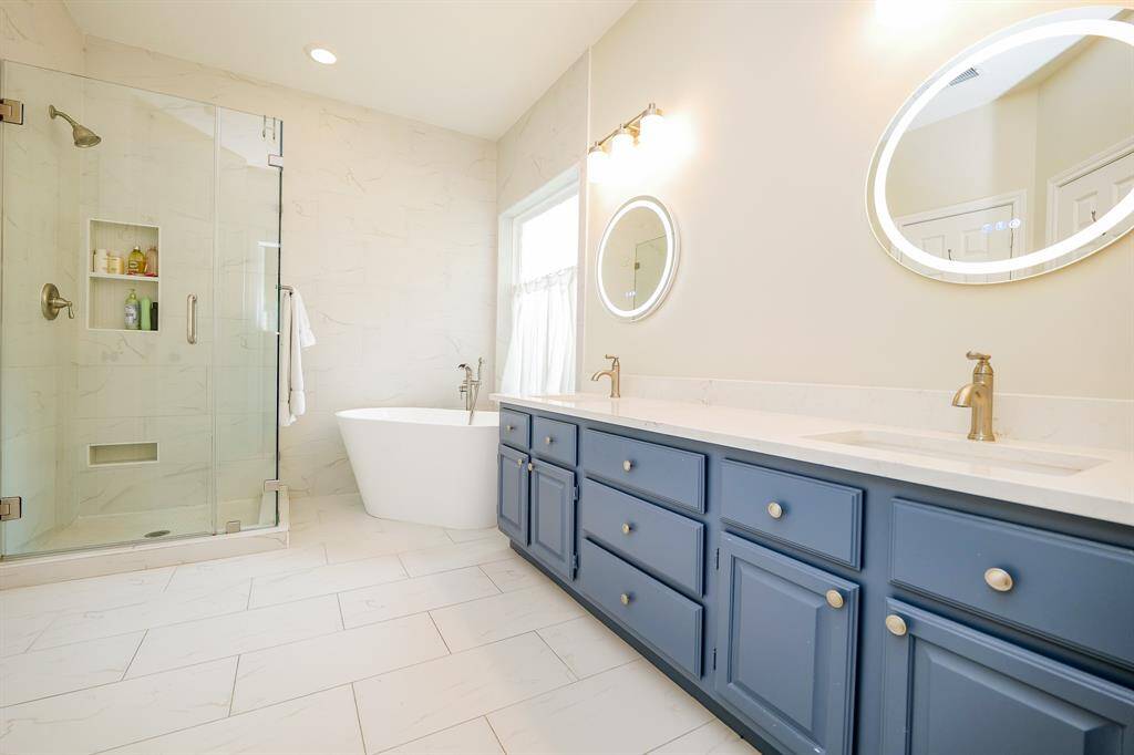 Luxurious primary bath showcases a freestanding soaking tub and sleek glass shower.