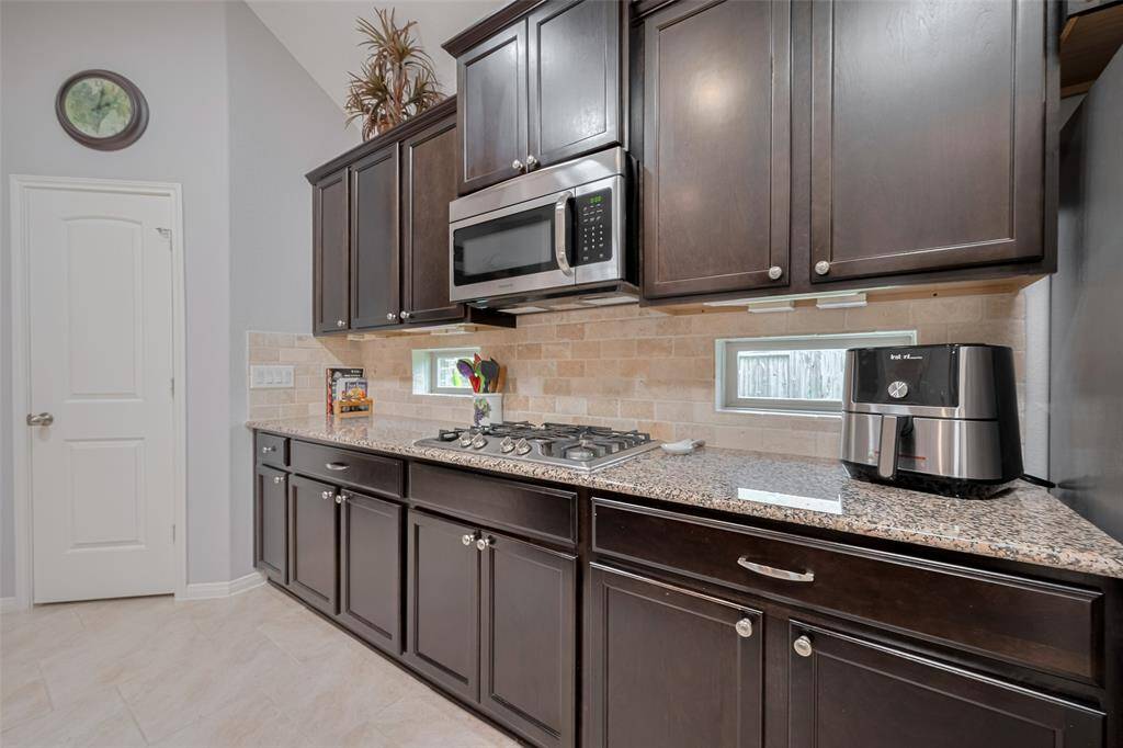 Enjoy a true chef’s setup with a built-in gas cooktop, stainless steel appliances, and open sightlines to the dining and living areas.