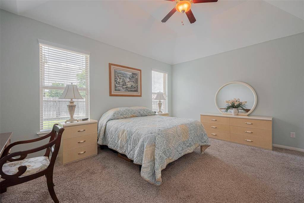 The spacious primary suite features vaulted ceilings and soft neutral tones, creating a calm and airy environment ideal for relaxation.