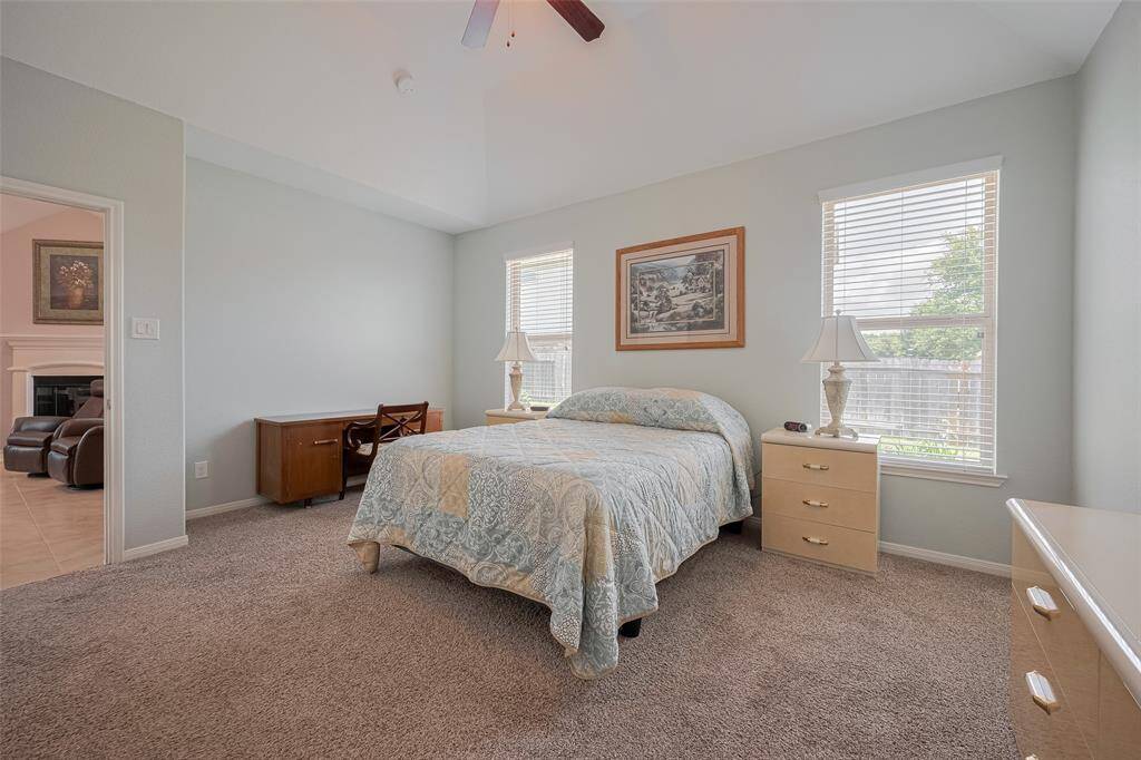Generous windows fill the room with natural light, enhancing the open feel and complementing the soothing color palette.