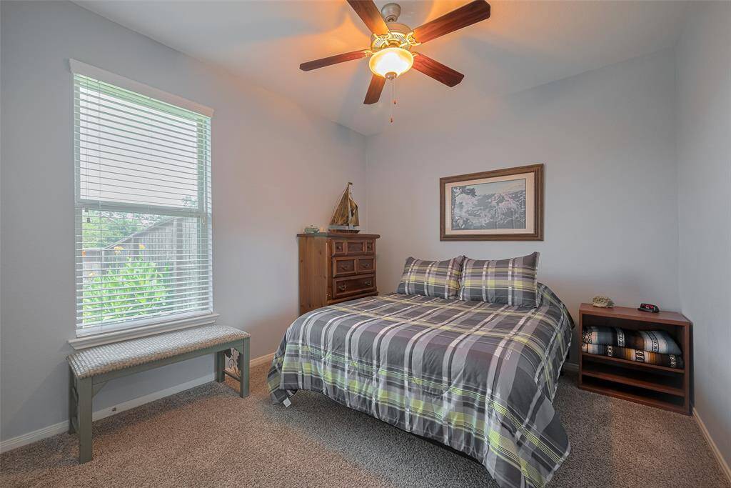 Large windows invite in natural light, enhancing the serene atmosphere and highlighting the room’s clean lines and plush carpeting.