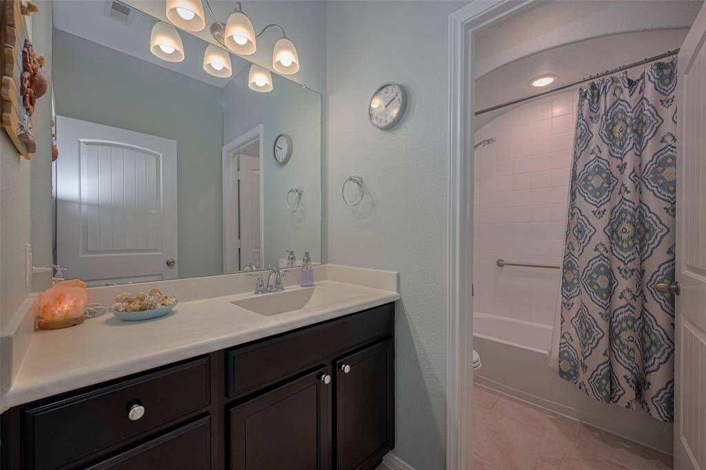 This full secondary bathroom includes a wide vanity with ample counter space and a separate tub/shower combo for added privacy and functionality.