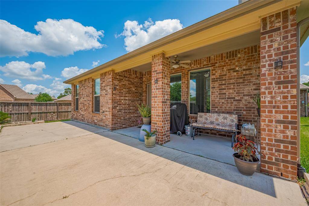 Brick columns frame the expansive concrete patio, perfect for outdoor dining or entertaining under wide Texas skies.