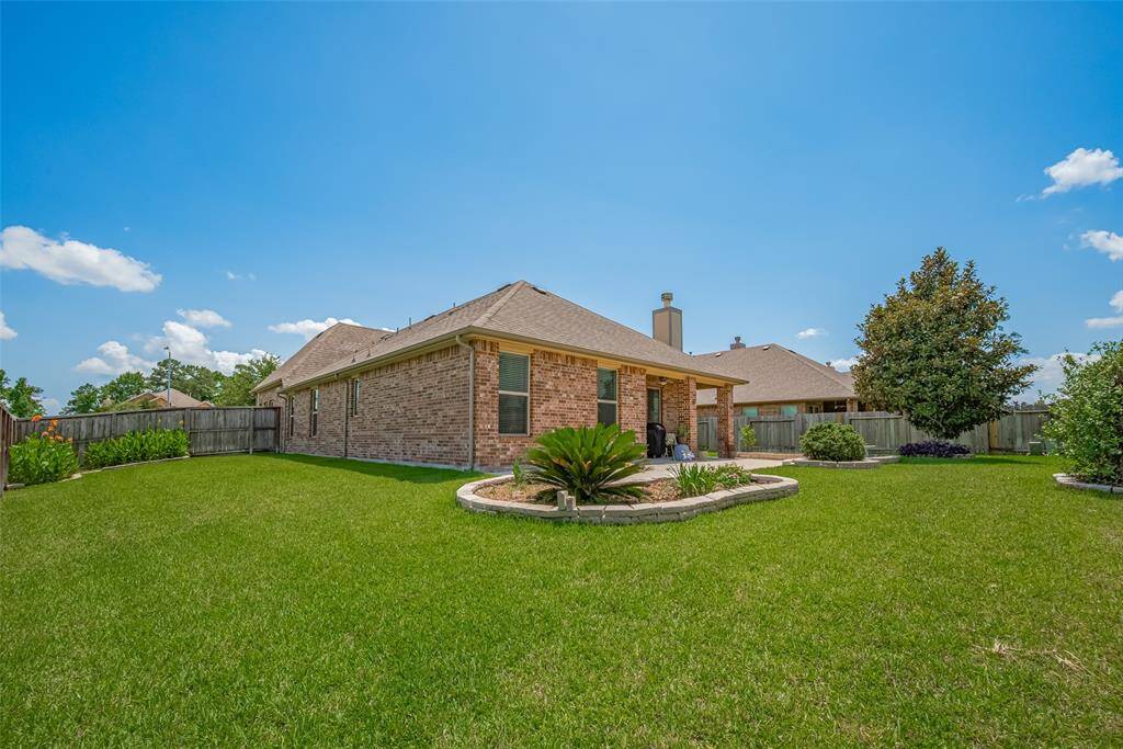 Full sprinkler system keeps the lawn lush and green. It wraps around the home with curved stone-lined beds adding texture and a touch of garden charm.