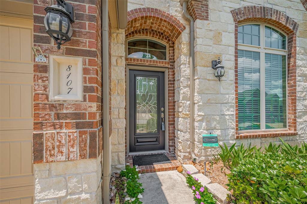 Charming entry with stone and brick accents, elegant lighting, and a stylish front door that sets the tone.