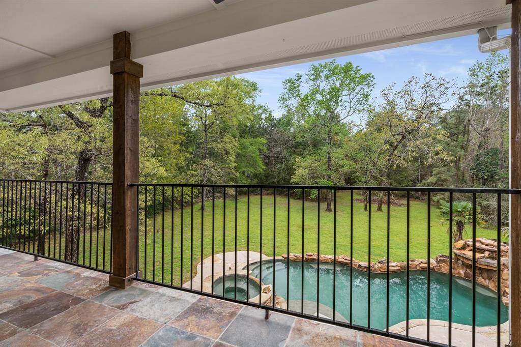 Private balcony from the game room overlooks back yard and sparkling pool
