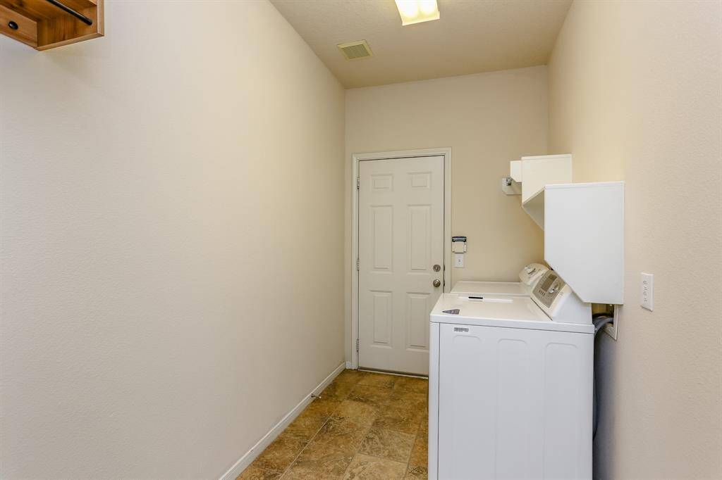 UTILITY ROOM WITH TILEFLOORS AND BUILT-INSHELVING TO HELP KEEPTHINGS ORGANIZED.