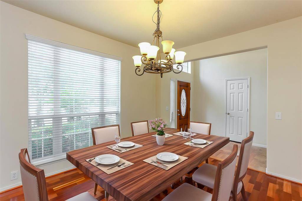 THE DINING ROOM FEATURESA WALL OF MIRRORS,CUSTOM CHANDELIER ANDPLENTY OF NATURAL LIGHT. **This room has been virtually staged.