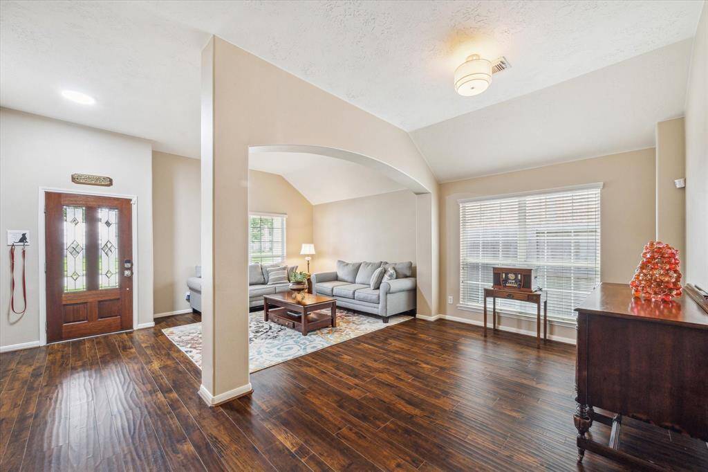 This inviting living space features an open layout with rich hardwood floors and large windows for natural light.