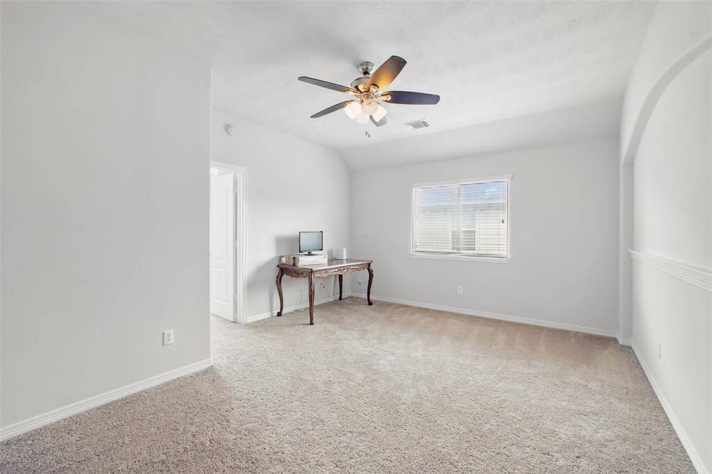 This flexible upstairs space is perfect for a game room, home office, media room, or second living area. It features soft neutral carpet, a ceiling fan for added comfort, and a large window that fills the room with natural light. The open layout and light color palette make it easy to customize to suit your needs.