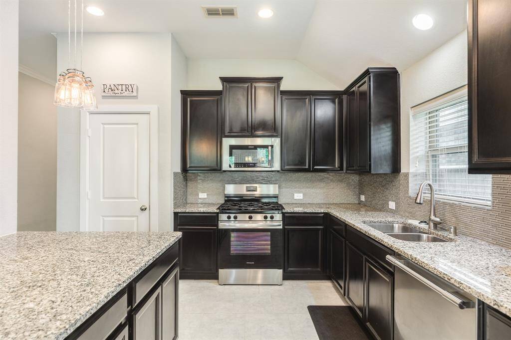 stainless steel appliances granite counter tops , pantry , window over the sink tile flooring lots of cabinet space