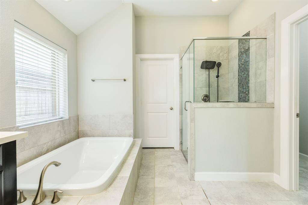 the shower is glass and till and is over sized with a rainhead