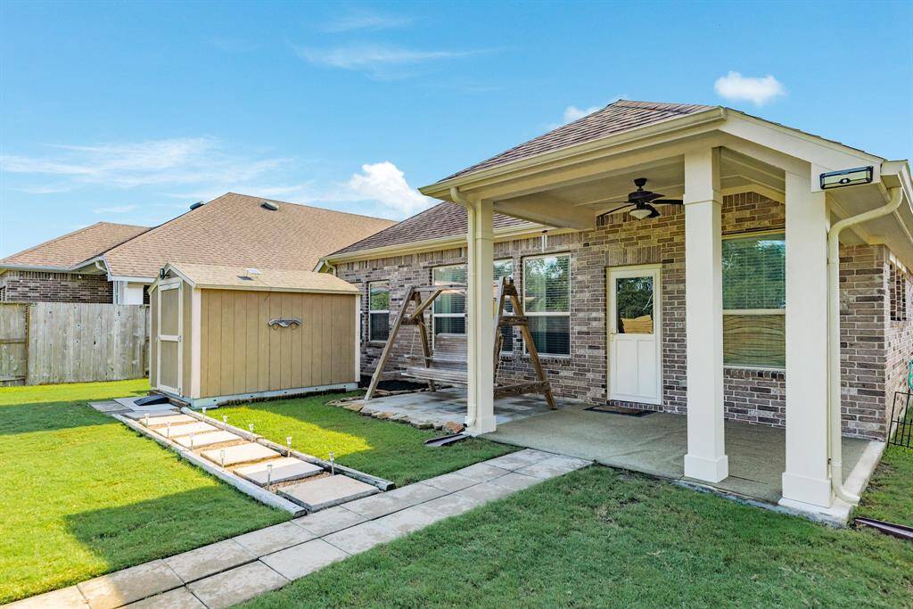 there is a path to the back yard area great for entertaining and path to the storage building , home also has gutters that is a plus