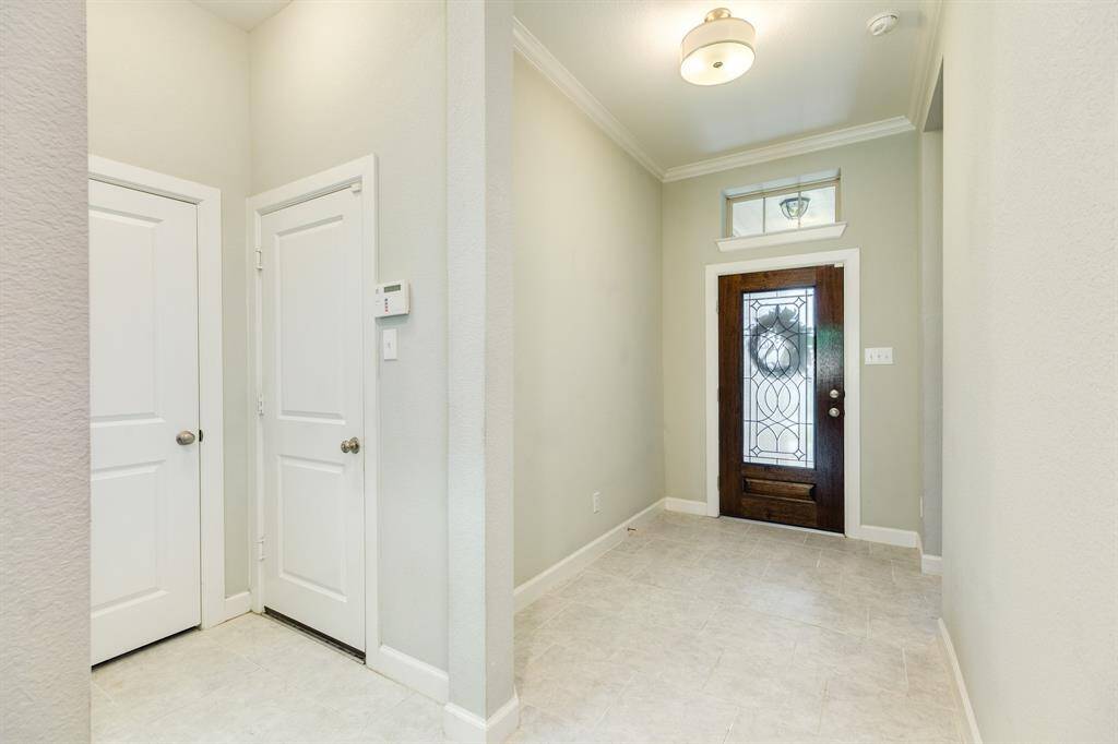 as you enter through this beautiful wooden and glass door on your left you have 2 bedrooms and bathroom as you walk towards the kitchen and family area on your right you have the garage door, closet and laundry room