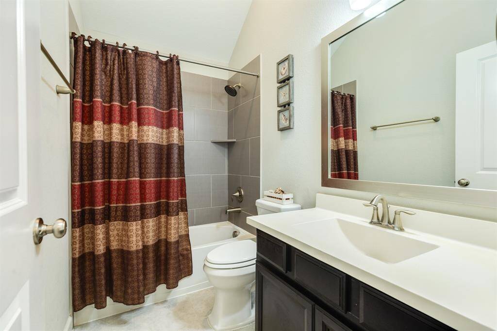 this bathroom is shared by the two bedrooms , you have your large mirror , shower tub combo
