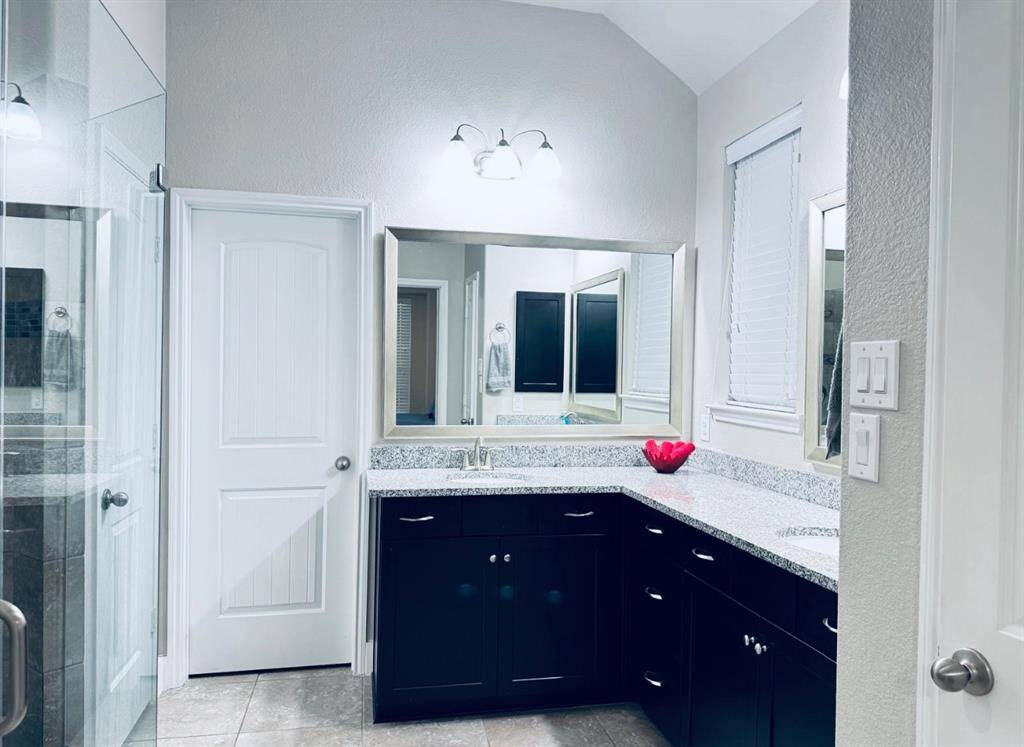Luxurious master bathroom featuring abundant granite countertops for a sleek and elegant touch.