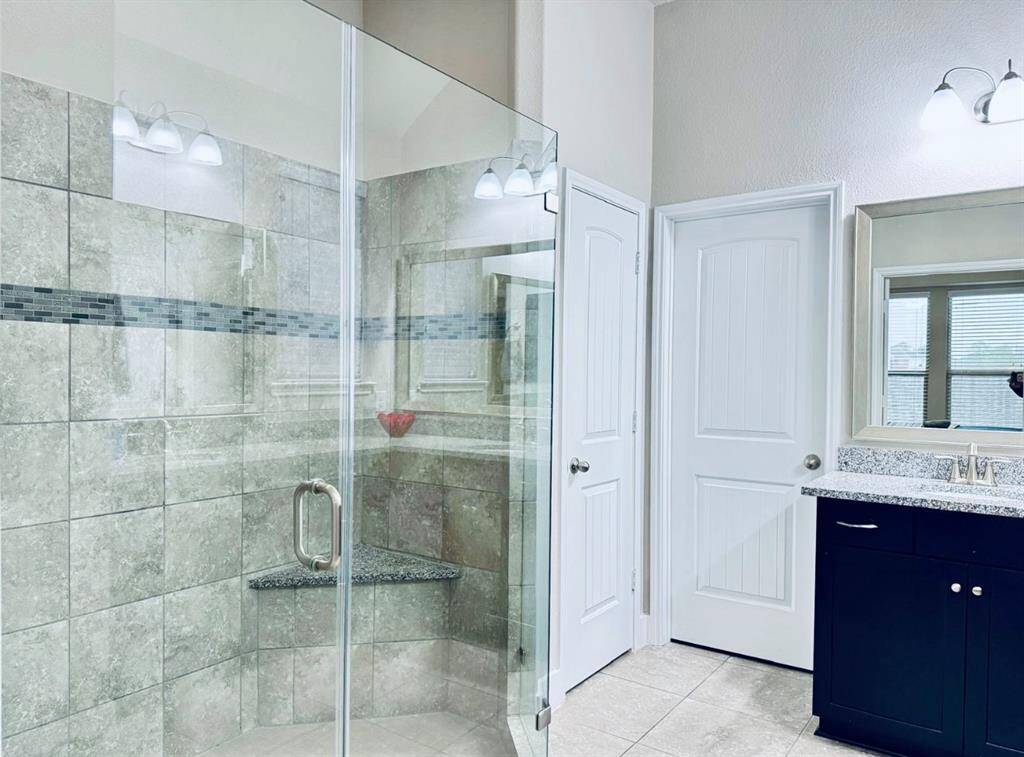 Luxurious spacious shower with sleek glass doors.