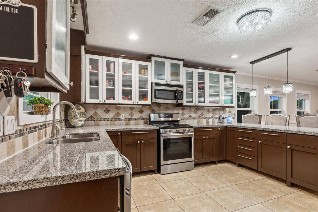 Open to the main living area, this kitchen keeps you connected while you cook or entertain. Recessed lighting and tile flooring enhance the bright and modern feel of the space.