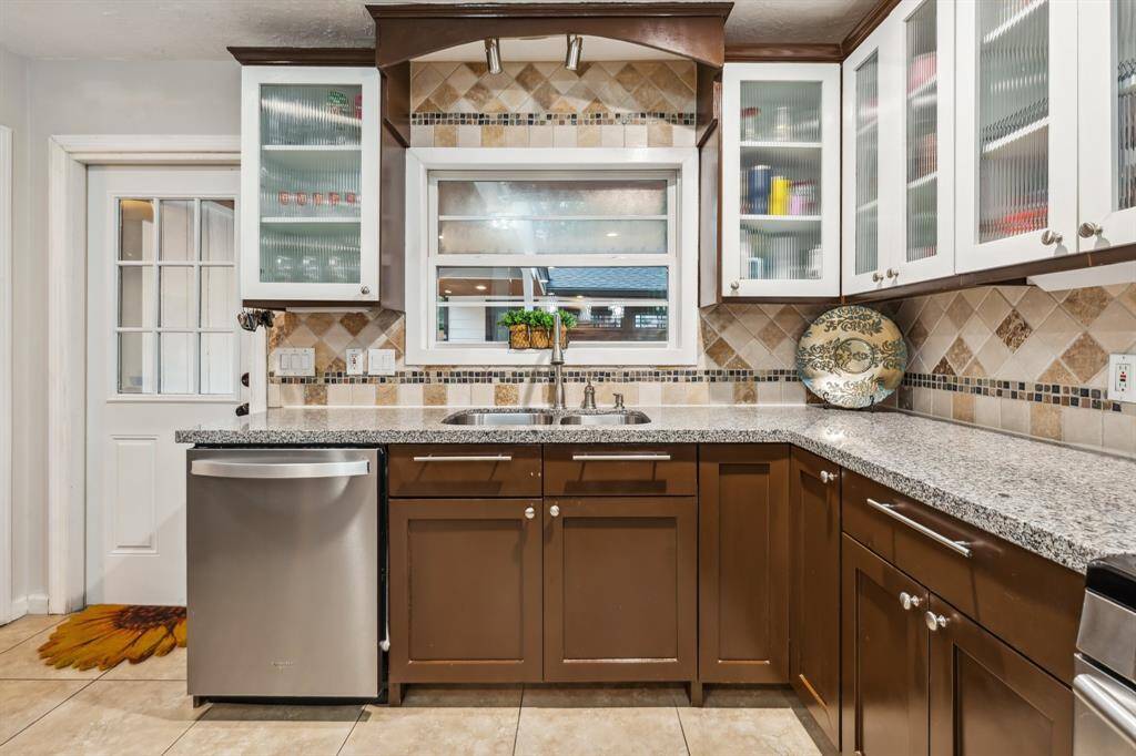 Equipped with sleek stainless steel appliances, this kitchen balances modern style and convenience. Floor-to-ceiling cabinetry maximizes storage without compromising aesthetics.