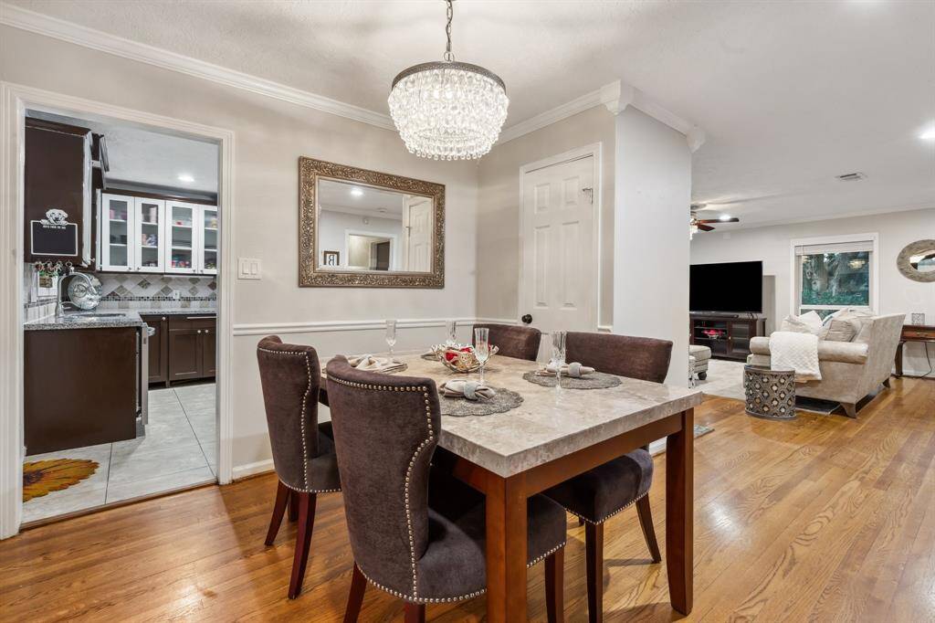 The formal dining area shines beneath an elegant crystal chandelier and comfortably connects to the kitchen, creating an ideal setting for holiday meals or everyday dining.