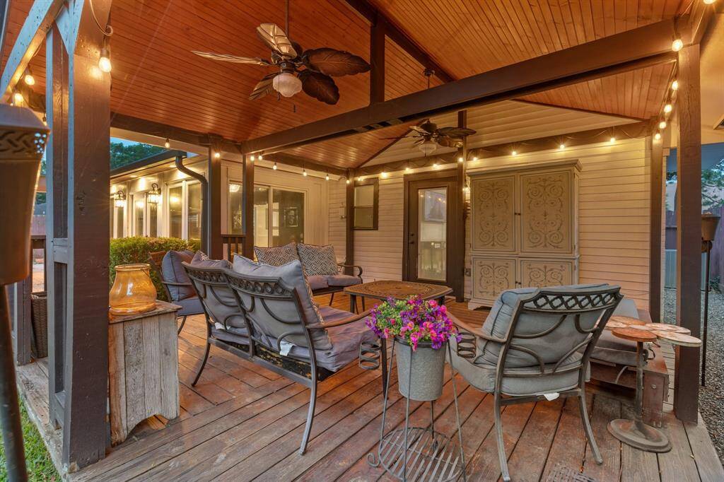 Featuring wood-look tile, elegant lighting, and backyard views, this versatile sunroom is the perfect transition space for relaxing, working, or entertaining.