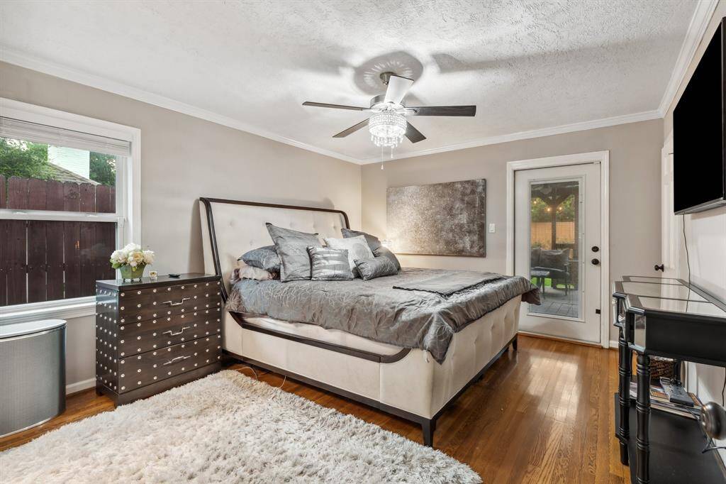 The spacious primary bedroom features hardwood floors, crown molding, and direct access to the backyard patio—offering a relaxing retreat with easy indoor-outdoor flow. Tucked privately in the rear of the home, the primary suite balances comfort and functionality with updated windows, neutral tones, and a seamless connection to the custom walk-in closet.