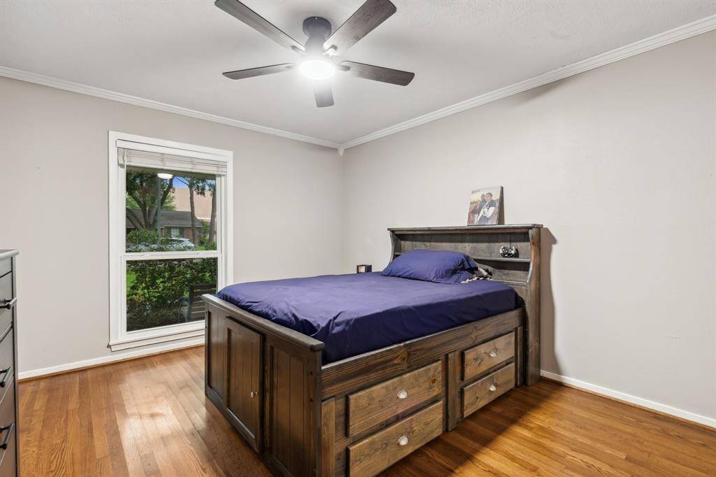This fully renovated bathroom features sleek herringbone tile flooring, a quartz countertop vanity with ample storage, and modern lighting. The walk-in shower includes custom tile detailing and glass enclosure for a clean, high-end look.